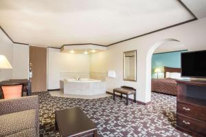 une chambre d'hôtel avec une baignoire et un lit dans l'établissement Super 8 by Wyndham Daleville/Roanoke, à Daleville