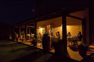 un gruppo di persone seduti intorno a un patio di notte di Antica Pinciana Agriturismo a Capalbio