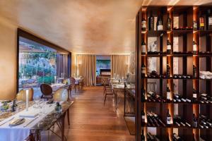 a dining room with tables and wine bottles at Sa Creu Nova Petit Palais Art & Spa in Campos