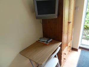 a small table with a television on a wall at Hillside Self Catering in Salisbury