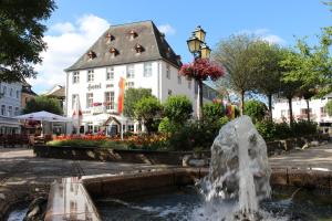 fontanna przed białym budynkiem w obiekcie Hotel Zum Stern w mieście Bad Neuenahr-Ahrweiler