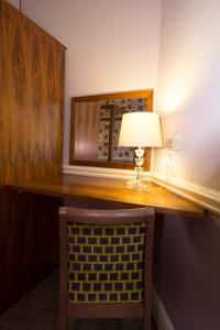 einen Schreibtisch mit einer Lampe und einem Stuhl in einem Zimmer in der Unterkunft Georgian House & Mews in York