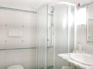 a white bathroom with a shower and a sink at Hotel Pupetto in Positano