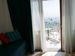 a room with a view of the ocean from a balcony at Hotel Pupetto in Positano