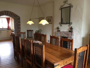 a dining room with a wooden table and chairs at Restored School Master’s House in Valentia Island