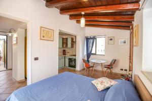 Schlafzimmer mit einem blauen Bett, einem Tisch und Stühlen in der Unterkunft La Terrazza di Viola in Scicli