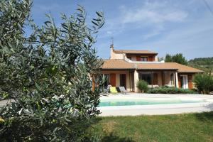 eine Villa mit einem Pool vor einem Haus in der Unterkunft La Villa des 3 ifs in Vallon-Pont-dʼArc