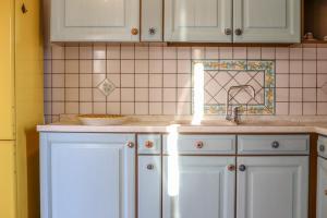 eine Küche mit weißen Schränken und einer Spüle in der Unterkunft La Terrazza di Viola in Scicli + 16 Fotos