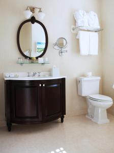 a bathroom with a sink and a toilet and a mirror at Delamar Southport in Southport +26 photos