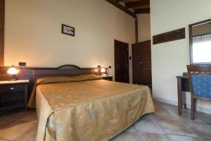 a bedroom with a bed and a table and a chair at Hotel Cà Fiore in Bardonecchia