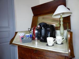 a counter with two coffee cups and a lamp on it at chambres d'hôtes les Muscaris in Feins-en-Gâtinais