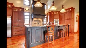 a kitchen with wooden cabinets and a island with bar stools at Affordable Luxury Mansion in Quincy