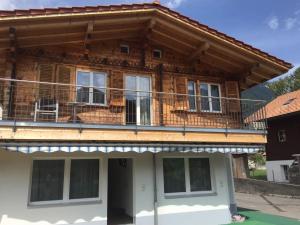 a house with a balcony on top of it at Swiss Chalet Holidays Ringgenberg in Ringgenberg