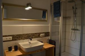 a bathroom with a sink and a shower with a mirror at Fewo Calico in Eging