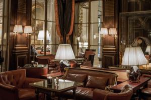 a lobby with couches and tables and lamps at Le Meurice – Dorchester Collection in Paris