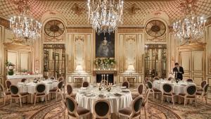 a ballroom with tables and chandeliers in a building at Le Meurice – Dorchester Collection in Paris