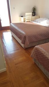 Schlafzimmer mit einem Bett und Holzboden in der Unterkunft Apartment Sara in Pirovac