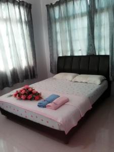 un letto con fiori sopra in una camera da letto di Penginapan MyCJ - Roomstay a Kuala Terengganu