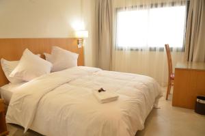 una camera da letto con un letto bianco con un vassoio sopra di Hotel El Bachir a Dakhla