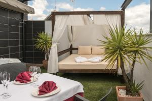 łóżko na patio z dwoma stołami i kieliszkami wina w obiekcie Hotel Macami w mieście El Carpio