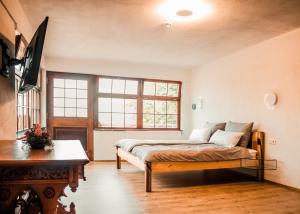 a bedroom with a bed and a tv in it at Wirgarten Antik Hotel in Dingolfing