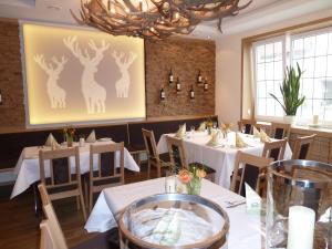 a dining room with tables and chairs and a painting of deer at Akzent Hotel Hubertus in Melle