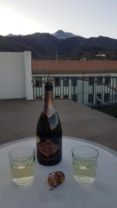 a bottle of wine and two glasses on a table at Cartoline Dall'Etna B&b in Zafferana Etnea