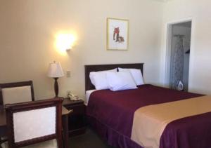 Habitación de hotel con cama y teléfono en Americas Best Value Inn Ozona en Ozona