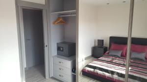 1 dormitorio con cama y espejo en Palm-Mar 2 rooms Lovely!!! en Arona