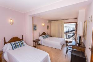 a hotel room with two beds and two lamps at Hotel Buigues in Moraira