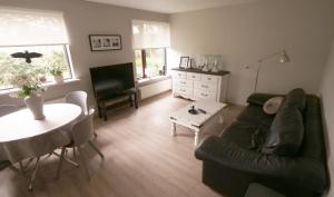 un soggiorno con divano e tavolo di Manahlid Apartment ad Akureyri