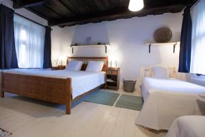 um quarto com 2 camas e cortinas azuis em Hét Fenyő Vendégház / Seven Pines Holiday House em Sukoró