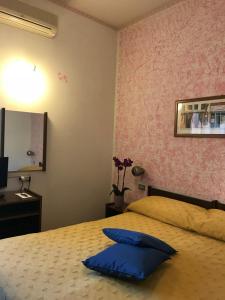 um quarto com uma cama com uma almofada azul em Albergo Hotel Garden Ristorante em Tabiano