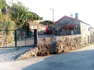 蓬蒂達巴爾卡的住宿－Casinhas do Minho，建筑前有门的石墙
