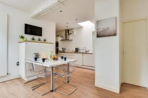 a kitchen with a table and chairs in a room at NOCNOC - Le grand National in Lille