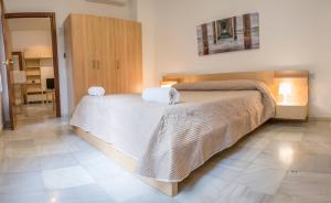 セビリアにあるPureza Dream Suiteのベッドルーム1室(大型ベッド1台、タオル付)
