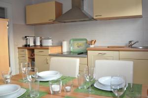 a kitchen with a table with plates and glasses on it at Landhaus Bruckner in Bad Alexandersbad