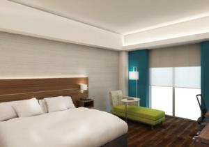 una camera d'albergo con letto e sedia verde di Holiday Inn Express Villahermosa by IHG a Villahermosa Altre 72 foto