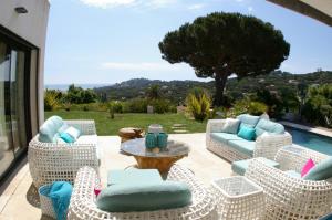 a patio with chairs and a table and a pool at Villa Happiness Sainte-Maxime in Sainte-Maxime