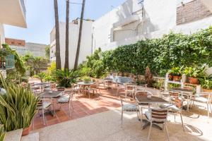 
a patio area with tables, chairs and umbrellas at Hotel Buigues in Moraira

