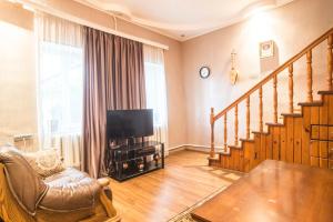 a living room with a couch and a television and stairs at Zukas Hause in Akhaltsikhe