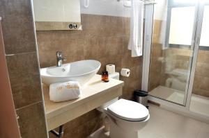 a bathroom with a sink and a toilet and a shower at Hotel El Bachir in Dakhla