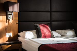 ein Schlafzimmer mit einem Bett mit schwarzem Kopfteil in der Unterkunft Club Hotel Cortina in Wien