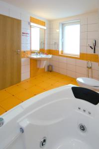 a bathroom with a tub, sink, and mirror at Hotel Ambient in Braşov