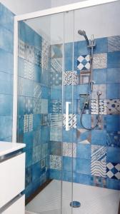 a bathroom with a shower with blue tiles at Gloria House in Levanto