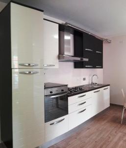 a kitchen with white cabinets and black appliances at Gloria House in Levanto