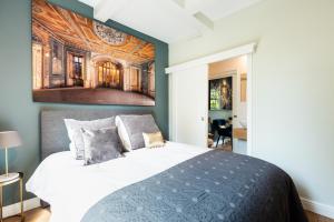 1 dormitorio con 1 cama con una pintura en la pared en Canal Wow Suites Amsterdam, en Ámsterdam