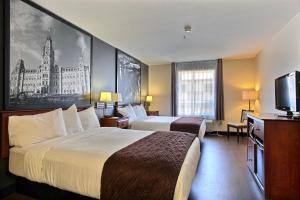 a hotel room with two beds and a flat screen tv at Super 8 by Wyndham Trois-Rivieres in Trois-Rivières +91 photos