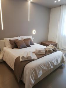 a bedroom with a large white bed with towels on it at Maison Saint Honorè in Foggia
