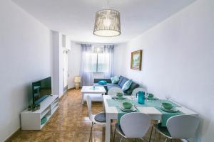 sala de estar con mesa y sofá en Las Gondolas Seaview, en La Manga del Mar Menor